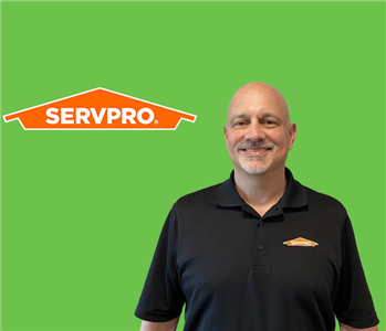 SERVPRO employee with wearing a black shirt in front of a green background