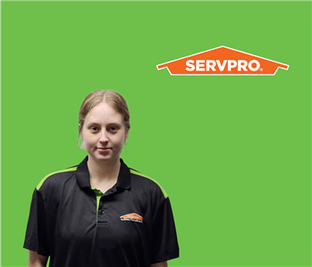 SERVPRO employee with light hair wearing a black shirt in front of a green background