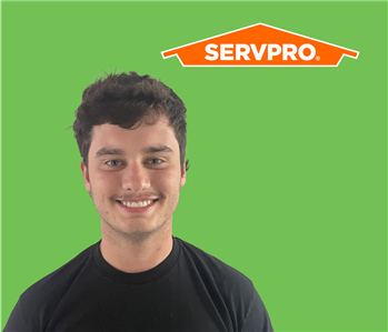 SERVPRO employee with dark hair wearing a black shirt in front of a green background