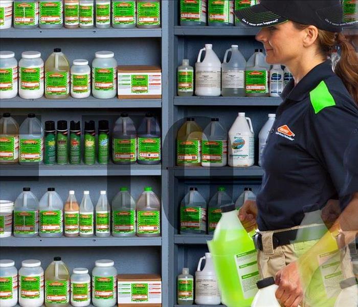 Woman with SERVPRO product, walking past shelves